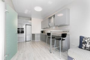 a kitchen with white cabinets and a table and chairs at Pearl 44 Apartment With Terrace in Odesa