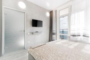 a bedroom with a bed and a tv on the wall at Pearl 44 Apartment With Terrace in Odesa