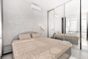 a white bedroom with a bed and a window at Pearl 44 Apartment With Terrace in Odesa