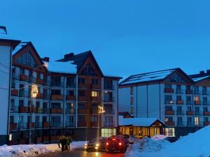 a group of people standing in the snow in front of a building at Twins apartment deluxe, new gudauri in Gudauri