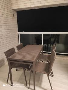 een houten tafel met twee stoelen en een groot scherm bij Salinas Park Resort Ap 506 para até 5 pessoas in Salinópolis