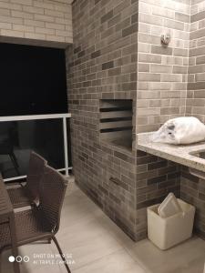 een badkamer met een bakstenen muur met een wastafel en 2 stoelen bij Salinas Park Resort Ap 506 para até 5 pessoas in Salinópolis