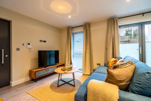 uma sala de estar com um sofá azul e uma televisão em Bootham Row 1 em York