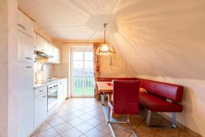 Maashof Schimmelreiter في هوسوم: مطبخ مع طاولة وكرسي احمر