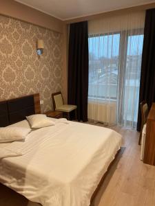 a bedroom with a large bed and a large window at Star Hotel in Tulcea