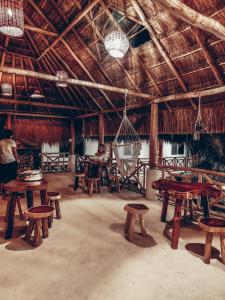 een grote kamer met houten tafels, banken en kroonluchters bij Hotel Xa´an Bacalar in Bacalar
