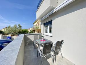 d'une terrasse avec une table et des chaises sur un balcon. dans l'établissement Olivia, à Medulin