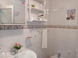 Baño blanco con lavabo y espejo en Casa típica de pueblo andaluz, en Villanueva de San Juan