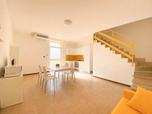 a kitchen and dining room with a table and a staircase at Le Naiadi Appartamenti in Bolsena