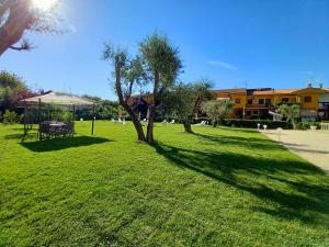 a park with a bench and trees in the grass at Le Naiadi Appartamenti in Bolsena