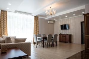 a living room with a dining room table and chairs at Park-Hotel Vishnevaya Gora in Saratov
