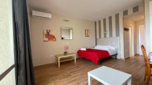 sypialnia z łóżkiem i czerwonym kocem w obiekcie estudio con vista al mar 19 w mieście Benalmádena