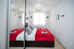 um quarto com uma cama com um cobertor vermelho em Bright 1BDR Apartment in the City Center em Sarajevo
