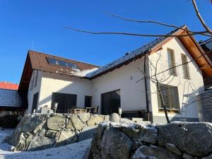 a house with a stone fence in front of it at Apartmán pri Dierach in Terchová +5 photos