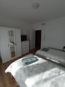 een slaapkamer met 2 bedden en een dressoir bij Maison al Bivio (Locazione Turistica) in Trichiana