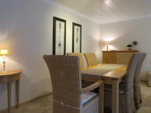 a dining room with a wooden table and chairs at Ferienhaus Süder-Tresker in Tinnum