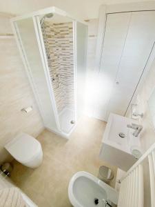 a bathroom with a toilet and a sink and a mirror at Le Naiadi Appartamenti in Bolsena