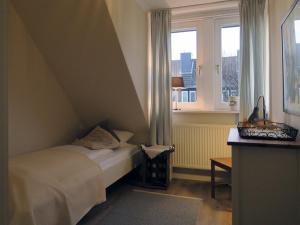 - une petite chambre avec un lit et une fenêtre dans l'établissement Ferienhaus Süder-Tresker, à Tinnum