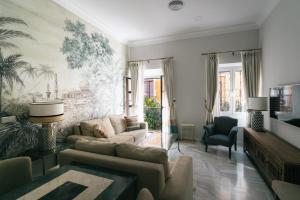 ein Wohnzimmer mit einem Sofa und einem Tisch in der Unterkunft Apartamentos Abreu Suites in Sevilla