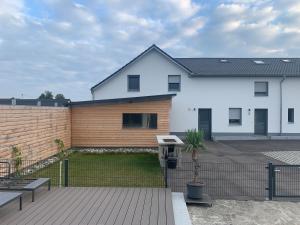 una casa blanca con una valla de madera en un patio en vista-apartments en Ebersbach
