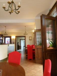 une salle à manger avec des chaises rouges et une table dans l'établissement Hotel Braník, à Prague