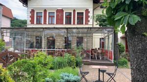 فندق Braník في براغ: منزل زجاجي به طاولة وكراسي في حديقة