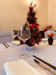 a table with three wine glasses and a christmas tree at Hotel Braník in Prague