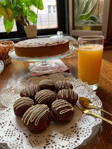 uma mesa com bolachas de chocolate, um bolo e um copo de sumo de laranja em Hotel Braník em Praga