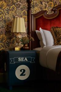 a bedroom with a bed and a table with a sign on it at Marine North Berwick in North Berwick