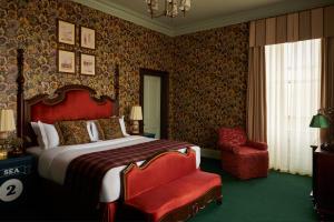 a bedroom with a large bed and a red chair at Marine North Berwick in North Berwick
