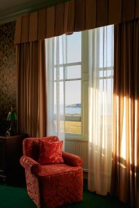 a living room with a chair and a large window at Marine North Berwick in North Berwick
