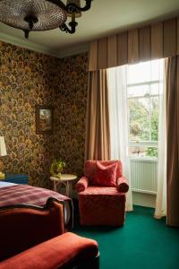 a bedroom with a red chair and a window at Marine North Berwick in North Berwick