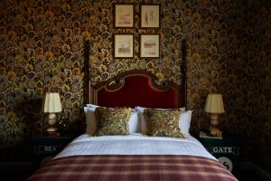 a bedroom with a bed with a red headboard and wallpaper at Marine North Berwick in North Berwick