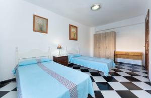 2 camas en una habitación con suelo a cuadros en Malaga downtown and beach apartment, en Málaga