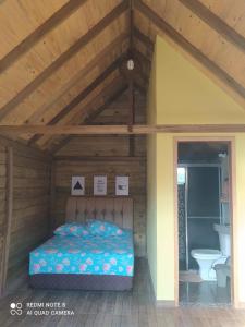 a bedroom in a wooden house with a bed at Chalés Rústicos e Românticos - Na terra das Cachoeiras in Faxinal