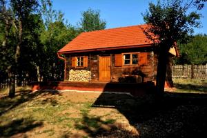 a small wooden house with an orange roof at Ličke radosti in Lapac Gornji