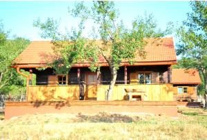 a house with a red roof in a field at Ličke radosti in Lapac Gornji