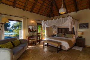 a bedroom with a bed and a couch at Matimba Bush Lodge in Phalaborwa