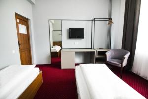 クルジュ・ナポカにあるCasa Bocaのベッド2台と鏡が備わるホテルルームです。