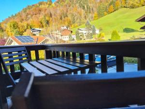 un banco en un balcón con vistas a la montaña en Water Lily Apartment, en Berchtesgaden 2 fotos más