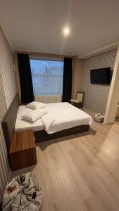 1 dormitorio con cama, mesa y TV en Star Hotel en Tulcea