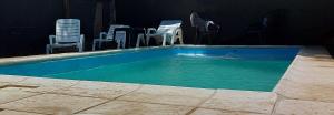 a swimming pool with chairs and a dog in the water at Merlo 1 in Merlo +11 photos