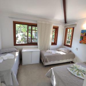 um quarto com 2 camas e 2 janelas em Duplex aconchegante Cond Reserva Praia do Forte em Mata de São João