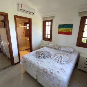 um quarto com uma cama num quarto com janelas em Duplex aconchegante Cond Reserva Praia do Forte em Mata de São João