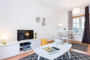 uma sala de estar com uma mesa e uma televisão em Delfimar Suite Alvor Apartment em Alvor