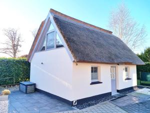 a small white cottage with a thatched roof at Haus Findling in Zingst