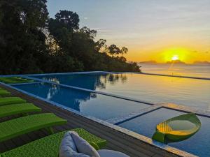 a infinity pool with a view of the ocean at sunset at Lime Resort El Nido in El Nido