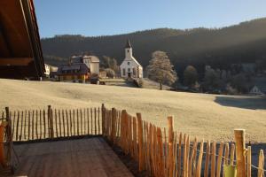 a fence on top of a hill with a church at s'heimatgfühl in Schwarzenberg