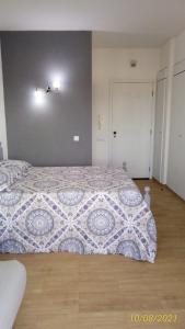 een slaapkamer met een bed met een quilt bij Sol e Praia Alvor 2 in Alvor