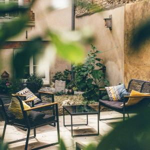 eine Terrasse mit Stühlen, einem Couchtisch und einer Pflanze in der Unterkunft Appartement calme Le clos de Renée in Hautvillers